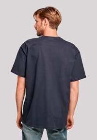 Navy cotton t-shirt with short sleeves, ribbed neckline, and a relaxed fit, featuring a smooth texture and slightly rounded hem.