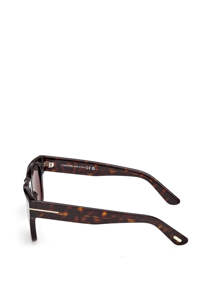 Lunettes de soleil écaille de tortue avec montures rectangulaires, présentant une texture lisse et des accents métalliques. Les branches sont ornées de gravures de la marque et du logo.