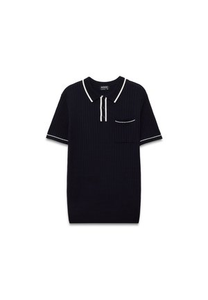 Polo de color azul marino con textura con ribetes blancos en el cuello y las mangas, que presenta una tapeta de tres botones y un bolsillo en el pecho.