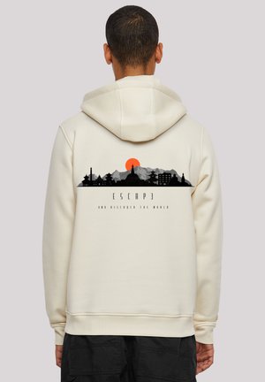 Cream hoodie featuring a graphic of a sunset over a mountain silhouette with the text "ESCAP3 AND DISCOVER THE WORLD" in black.