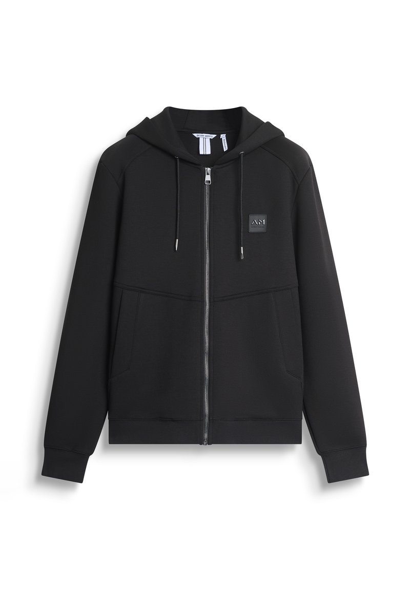 Felpa nera con zip, dotata di cappuccio, tasche frontali, polsini a coste e una patch logo testurizzata sul petto. Realizzata in tessuto morbido.