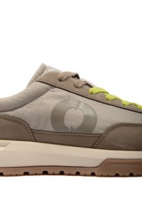 Vue latérale d'une basket beige et marron avec des lacets vert clair et un logo circulaire sur la tige en tissu au-dessus de la semelle en caoutchouc épaisse.