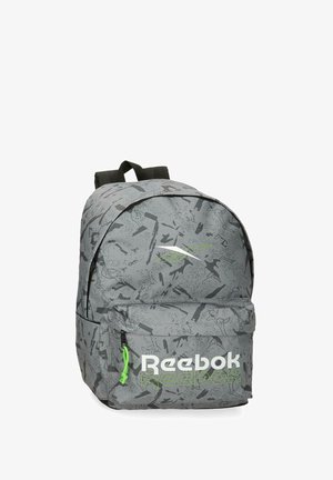 Mochila gris de Reebok con patrón negro abstracto, bolsillo frontal con cremallera con el logo de Reebok en blanco y verde, y correas de hombro negras ajustables.