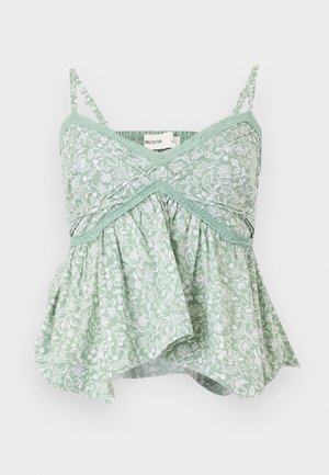 Mėtų žaliu spalvotu gėlių raštu dekoruota kamšytė su plonomis reguliuojamomis petnešėlėmis, nėrinių apdaila ir platėjantis apatinis dizainas. Lengvas medvilnės audinys.