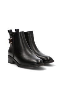 Botas de tobillo de cuero negro con una textura suave, tacón bajo apilado y detalles en tono dorado. Cuentan con tiradores en la parte posterior.