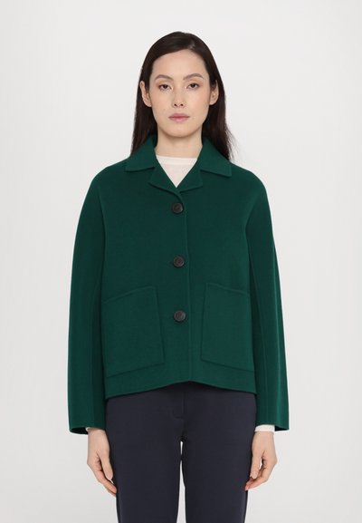 Jachetă din lână de culoare verde, cu guler, patru butoane negre și două buzunare frontale. Are mâneci largi și un design scurt.