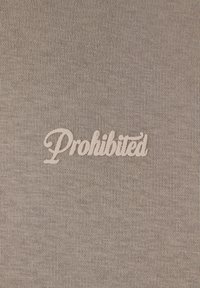 Tissu gris avec une texture lisse présentant le mot "Interdit" brodé en lettres cursives blanches.