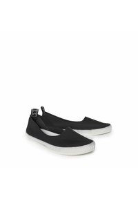 Sorte slip-on sko med en glat tekstiloverdel, spids tådesign og en kontrasterende hvid gummisåle med et struktureret mønster.