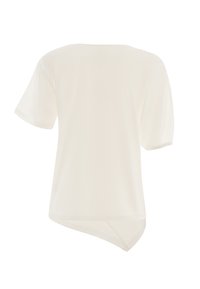 Blusa a maniche corte in bianco sporco, caratterizzata da una linea dritta con orlo leggermente asimmetrico e una texture di tessuto morbido e liscio.
