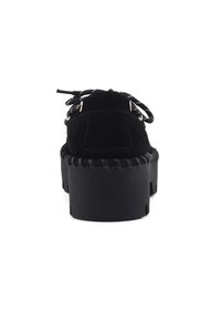 Scarpa platform in suede nero con suola spessa e rigata, lacci a fantasia bianca e nera, vista da dietro su sfondo bianco.