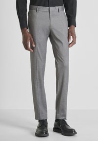 Sive tailored hlače s glatkom teksturom, s ravnim prednjim dijelom i suptilnim uzorkom, uparene s crnim poslovnim cipelama.