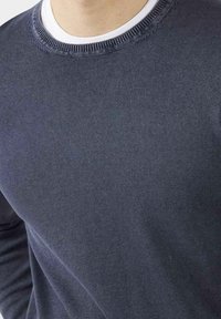 Maglione a maglia blu scuro con scollo rotondo e colletto a costine. Morbido al tatto con una finitura liscia, dettagli minimi. Maniche lunghe visibili.