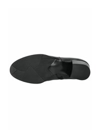 Soletta nera in gomma con superficie testurizzata; presenta una forma elegante e sagomata, dal design flessibile. Nota il motivo distintivo sul tallone.