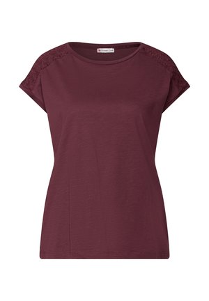 Burgundin T-paita lyhyillä hihoilla, pyöreällä kaula-aukolla ja pitsikoristeilla hartioilla. Pehmeä tekstuuri, rento istuvuus ja yksinkertainen muotoilu.