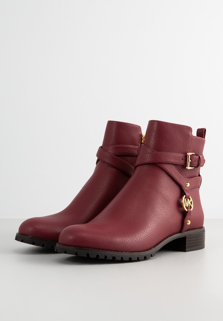 Burgunderrote Leder-Stiefeletten mit strukturiertem Finish, ausgestattet mit einer seitlichen Schnalle, goldfarbener Hardware und einer robusten Gummisohle.