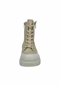 Stivale alla caviglia in suede beige con lacci sul davanti, zip laterali e suola bianca spessa. Presenta una texture liscia e un design minimalista.