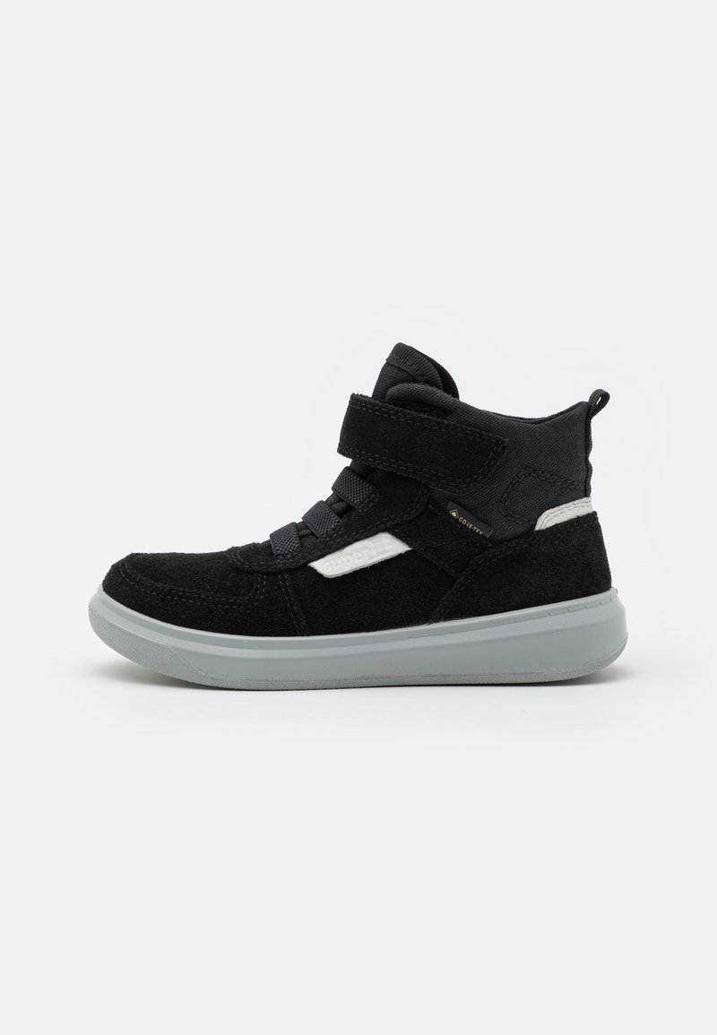 Baskets montantes noires en daim, avec une bride en Velcro, un détail à lacets, et une semelle en caoutchouc gris clair. Présente un accent blanc sur le côté.
