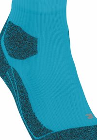 Calcetín azul hasta el tobillo con áreas de talón y puntera reforzadas en negro, puño acanalado y un pequeño logo gris cerca de la puntera.