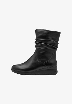 Bottines noires en cuir brillant, avec un design flou, un bout rond et une semelle en wedge basse pour le confort.