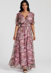 Maxiklänning i genomskinlig rosa tyg med ett blommigt bladmönster. Har en v-ringning, volangärmar och en cinchad midja.