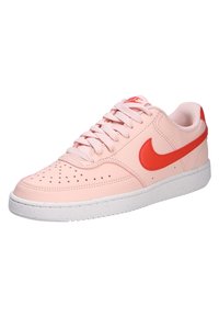 Sneaker in pelle rosa con Swoosh Nike rosso, punta perforata e lacci rosa chiaro. Suola bianca con macchie, design della punta arrotondata.