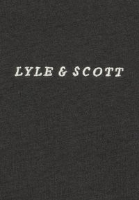 Black fabric with white embroidered text "LYLE & SCOTT" centered on the surface.