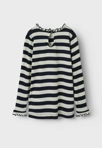 Pasiasty, długi rękaw, w kolorach granatowym i kremowym, z dekoltem w kształcie łezki z tyłu oraz falbaniastymi mankietami z falistym wykończeniem. Miękka tkanina i luźny krój.