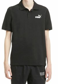 Zwarte polo gemaakt van katoen, met een kraag, korte mouwen en een wit Puma-logo op de borst. Gladde textuur, klassieke pasvorm.