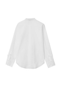 Chemise blanche à manches longues avec un col pointu, des poignets boutonnés et un ourlet arrondi. Texture lisse, sans motifs ni graphiques visibles.