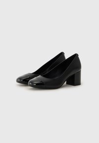 Scarpe con tacco nere con punta arrotondata e dettaglio lucido. Realizzate in pelle liscia e dotate di un tacco largo per maggiore stabilità.