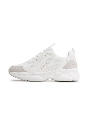 Zapatilla blanca con detalles de malla y ante, que presenta una parte superior texturizada, cuello acolchado y una suela gruesa de goma con diseño ondulado.