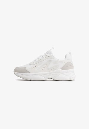 White sneaker with mesh and suede accents, featuring a textured upper, padded collar, and a thick rubber sole with a wavy design.