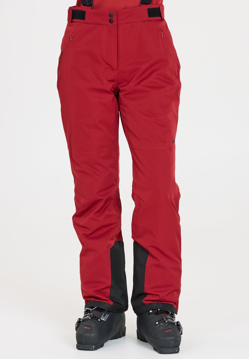 Röda isolerade skidbyxor med vattentätt material, justerbara remmar, blixtlåsfickor och svarta detaljer vid fållarna. Lämpliga för vintersport.