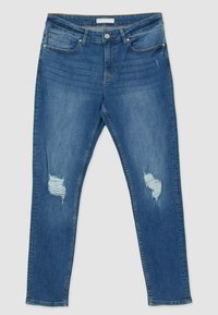 Jeans in denim blu con un design aderente, dotati di due tasche frontali, una piccola tasca posteriore e con delle scoloriture sulle ginocchia.