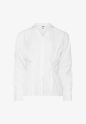 Blouse blanche à manches longues avec un col pointu, un devant boutonné et des côtés légèrement froncés créant une coupe ajustée.