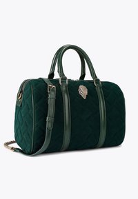 Quiltowana zielona torebka z skórzanymi akcentami, podwójnymi uchwytami, regulowanym paskiem na ramię oraz ozdobnym metalowym detalem.