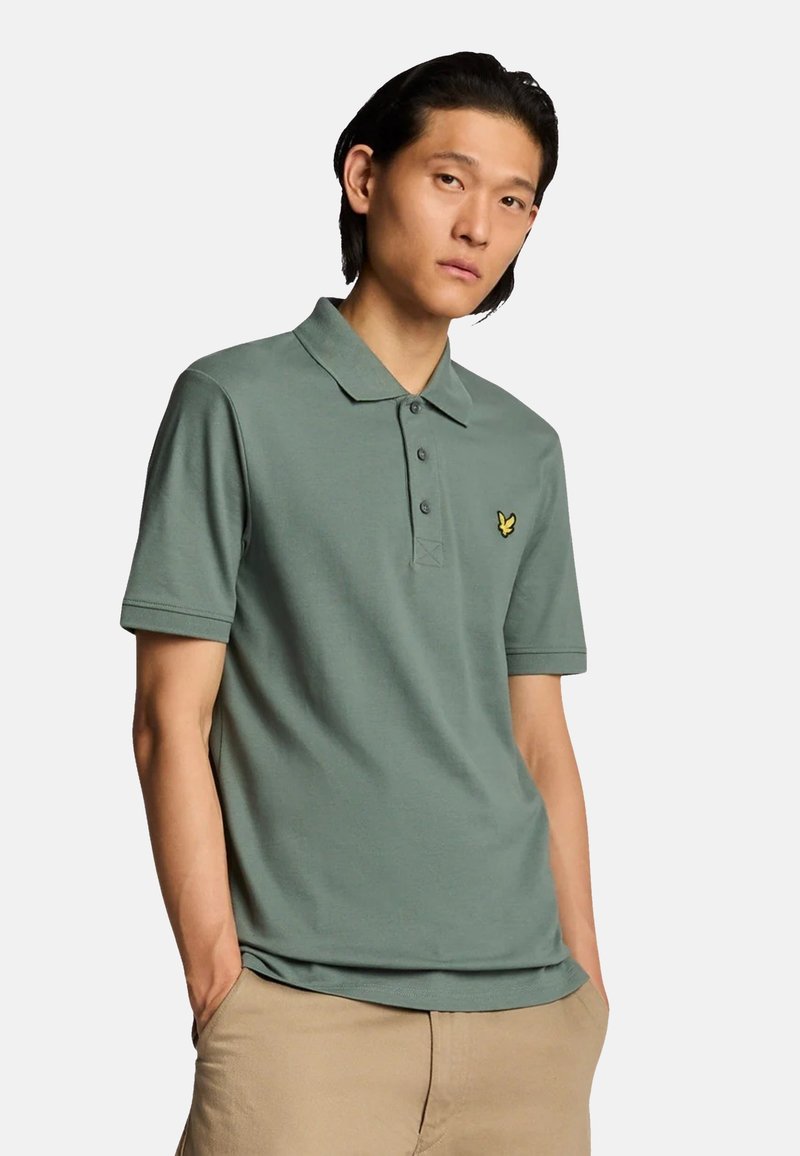 Polo shirt verde in misto cotone, con colletto e patta con tre bottoni. Piccolo logo giallo sul petto.