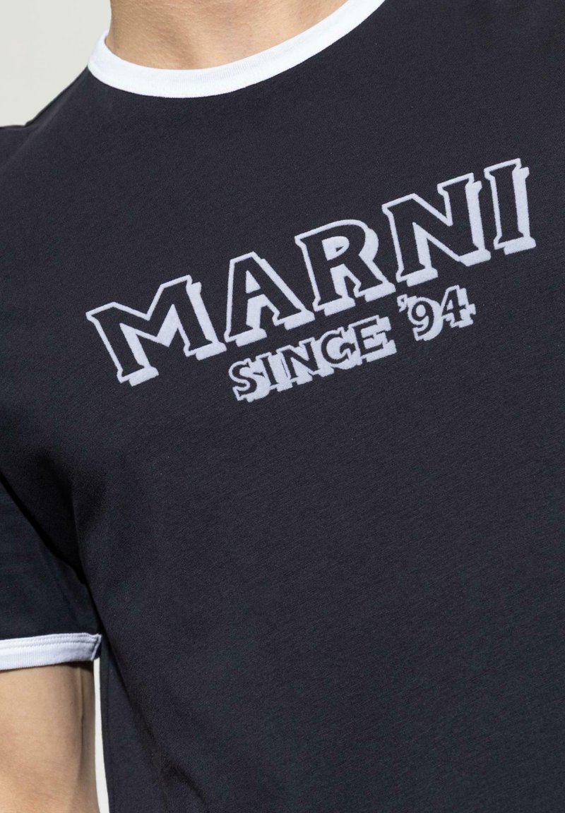 T-shirt noir avec bordure blanche au col et aux poignets, arborant l'inscription « MARNI SINCE '94 » en lettres blanches en gras sur la poitrine.