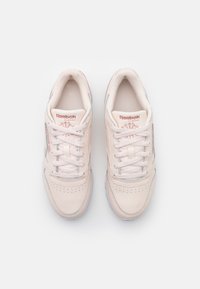Reebok Classic sneakers i mjuk rosa läder, med snörning, perforerade detaljer och subtila logotypaccenter på tungan.