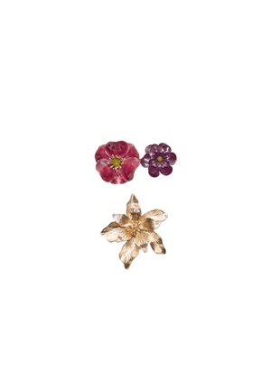Three flower-themed accessories: two pink enameled flowers with central accents, and one gold-tone metal flower with textured petals.