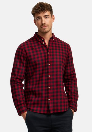 Rode en zwarte geruite flanellen shirt met een knoopsluiting kraag. Heeft lange mouwen en een knoopsluiting aan de voorkant. Zachte, gestructureerde stof.