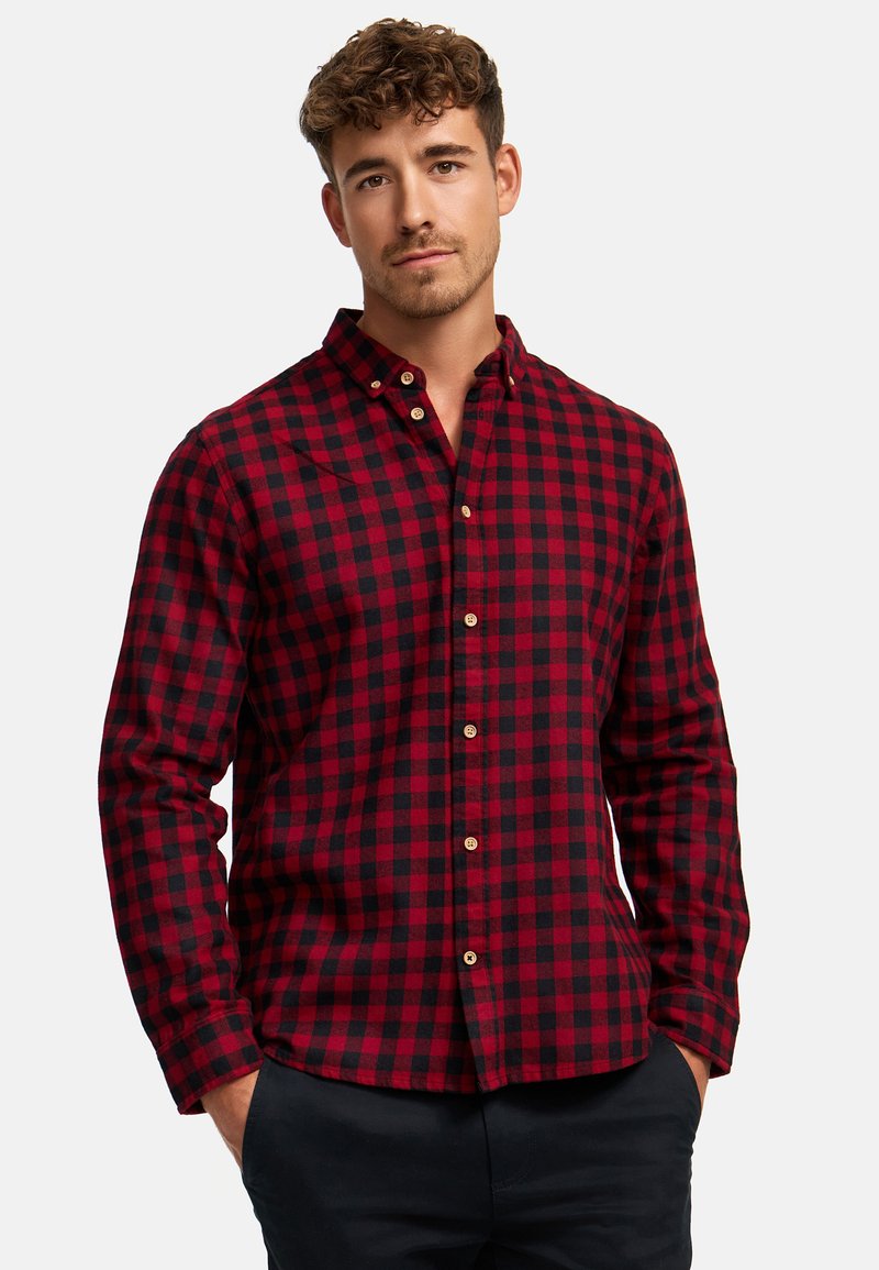 Camisa de franela a cuadros rojos y negros con cuello abotonado. Cuenta con mangas largas y botones en el frente. Tejido suave y texturizado.
