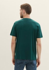 Grøn bomulds t-shirt med korte ærmer og rund halsudskæring, glat tekstur og enkelt design, set bagfra.