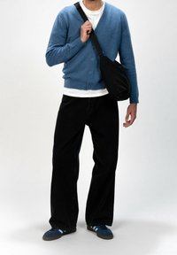 Světlomodrý pletený kardigan s knoflíky, b�ílé tričko, černé široké džíny a modré tenisky s proužky. Zobrazená černá kabelka přes rameno.