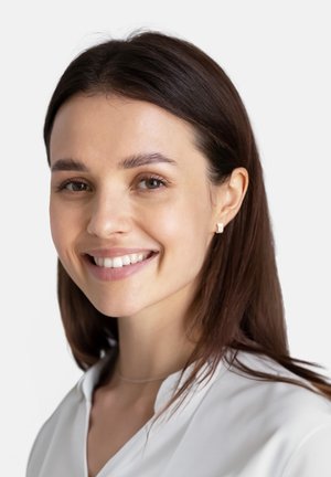 Lächelnde Frau mit braunen Haaren trägt kleine silberne quadratische Ohrringe und eine weiße Bluse. Klare Haut, natürliches Make-up und neutraler Hintergrund.