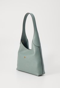 Soft, textured leather handbag in muted teal. Features a curved handle, gold accent stud, and contrasting dark stitching along the edges.