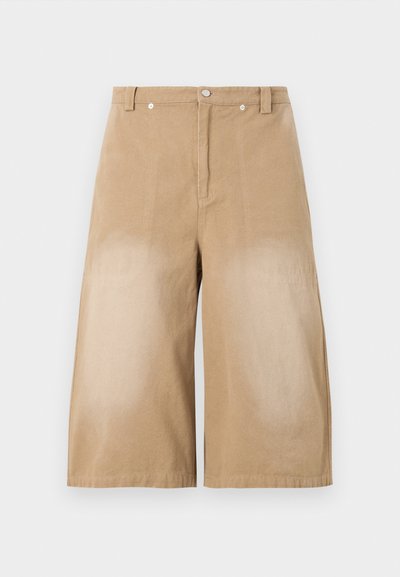 Beige vide shorts laget av bomull, med frontlås, to lommer og sydd detaljer langs sømmene.