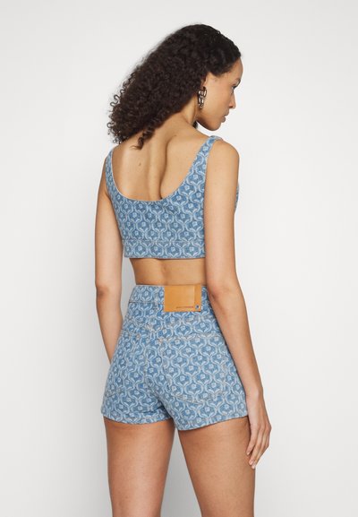 Blue patterned crop top and high-waisted shorts, featuring a textured design, thick straps, and a tan leather patch on the back.