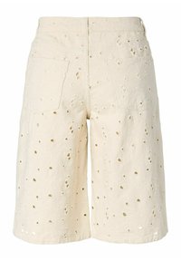 Shorts en tissu couleur crème avec des œillets brodés et des poches plaquées à l'arrière, vus de dos.