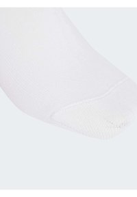 Weißer Baumwollsocken mit strukturierten Oberflächen, abgerundetem Zehenbereich und verstärkter Ferse, entworfen für Komfort und Langlebigkeit.